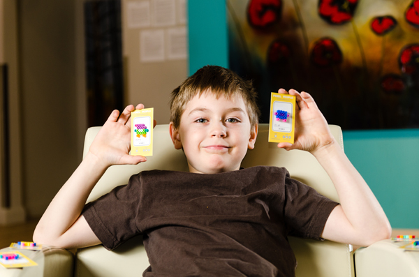 Malcolm Hicks, 8, shows off his Pixel People at Pop-Up Gallery in Westboro. ?The Pixel People can be purchased online or in the gallery, with all proceeds going ?to buy toys for children in need. Photo by Ted Simpson.