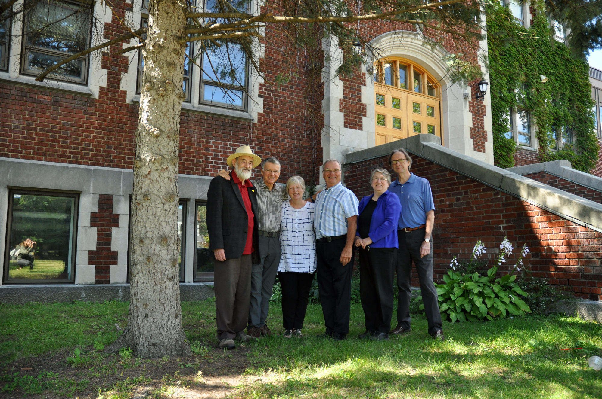 (L-R) Peter MacKinnon, Ian Ramsay, Margaret Haines, Bill Cowie, Martha Aksim, Bruce MacLeod pictured next to one of the evergreens their graduating class planted at Nepean High School. Photo by Andrea Tomkins