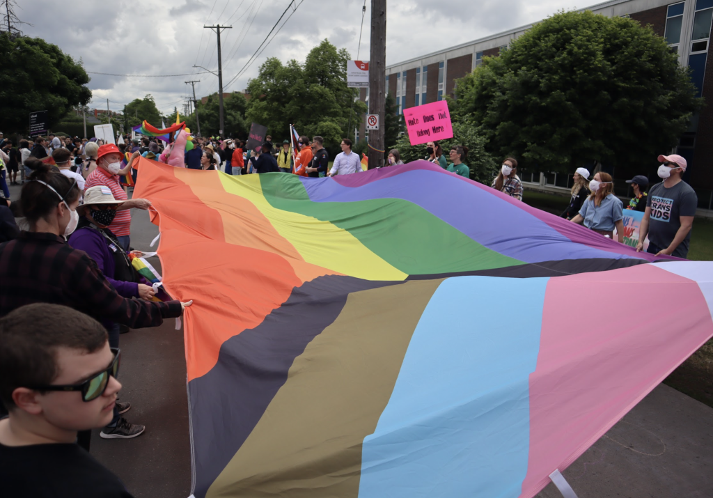 Demonstrators hold a large Pride flag on Brodview near Notre Dame High School.  