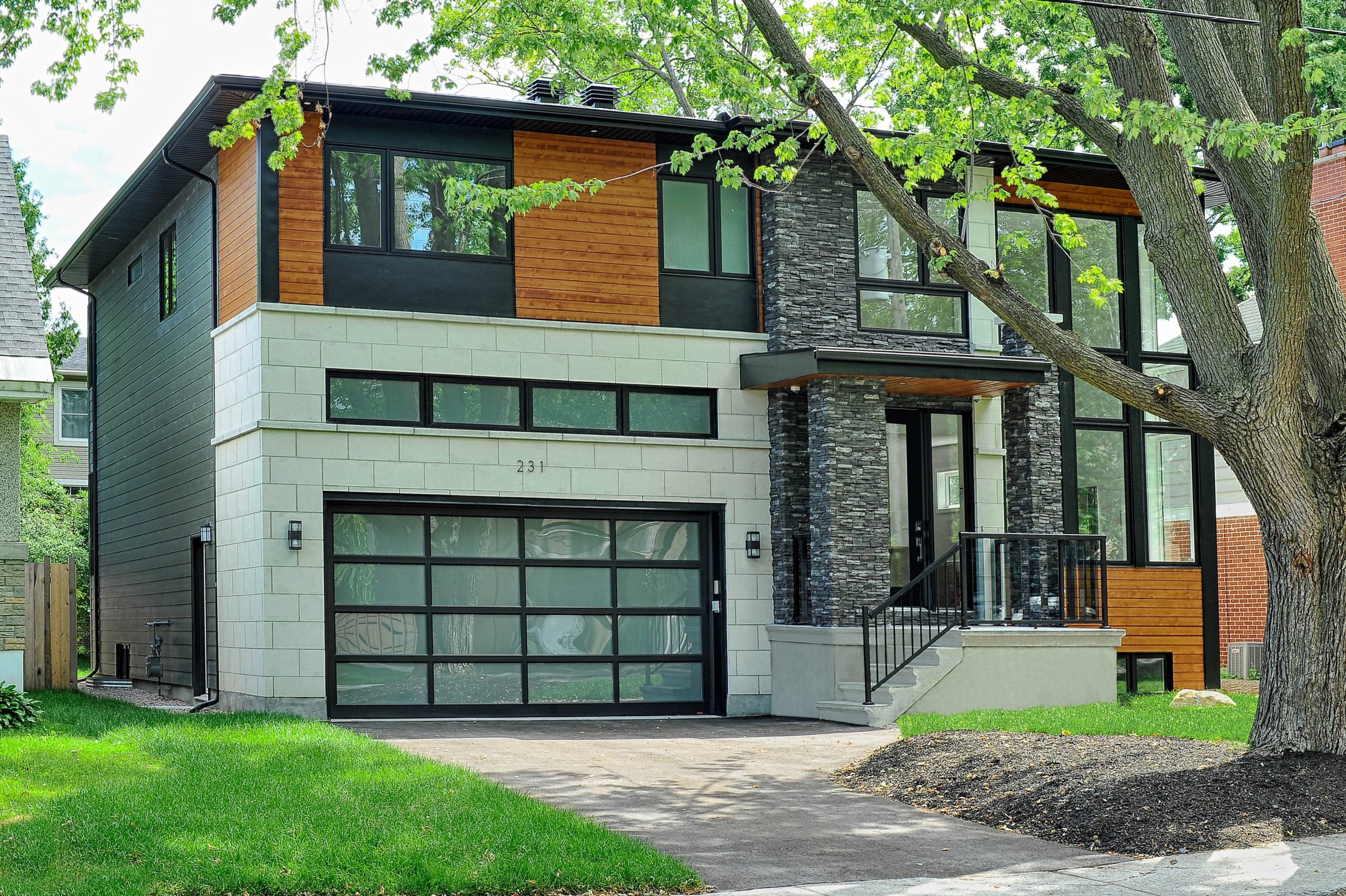 The exterior of a modern house that is squared in shape. 