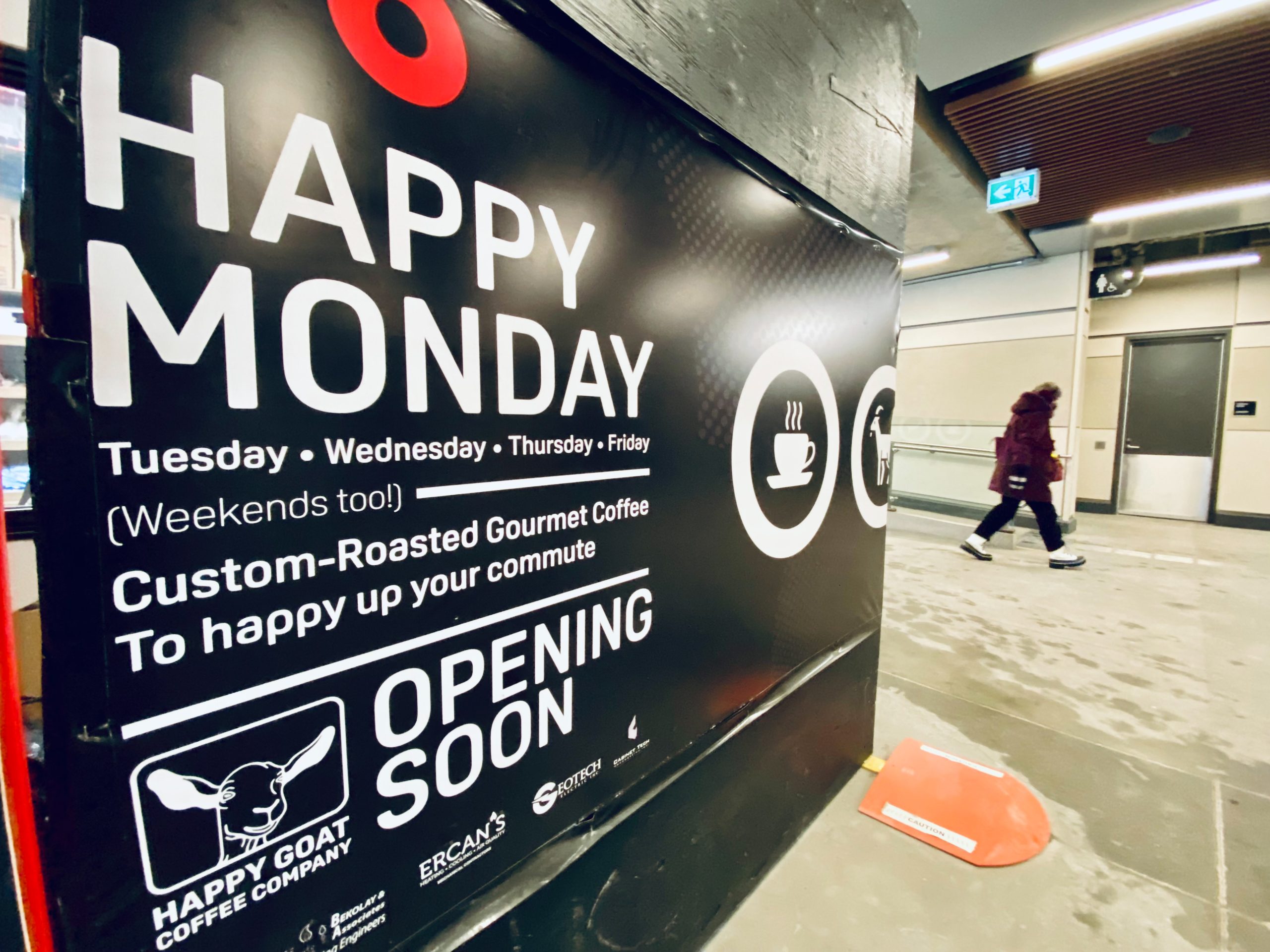 A black and red Happy Goat sign at an LRT station in Ottawa