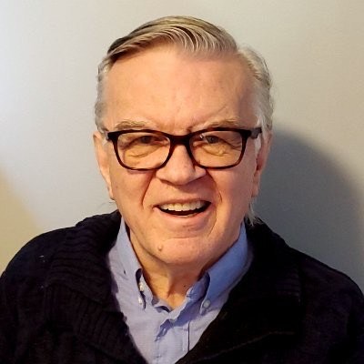 A close up of an older man wearing black glasses