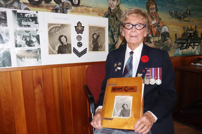 Connie Mooney rakes some of her artifacts from her time serving during World War II to commemorate Remembrance Day.