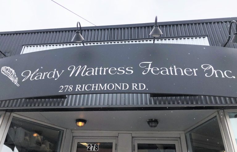 The storefront sign for Hardy Mattress Feather Inc. written in white. The address is beneath the name