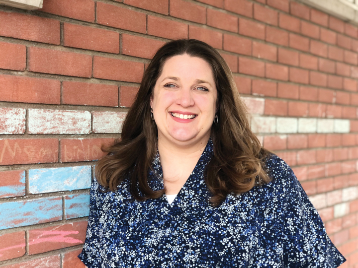 Judy Lincoln leans on a red brick wall in Westboro for a headshot