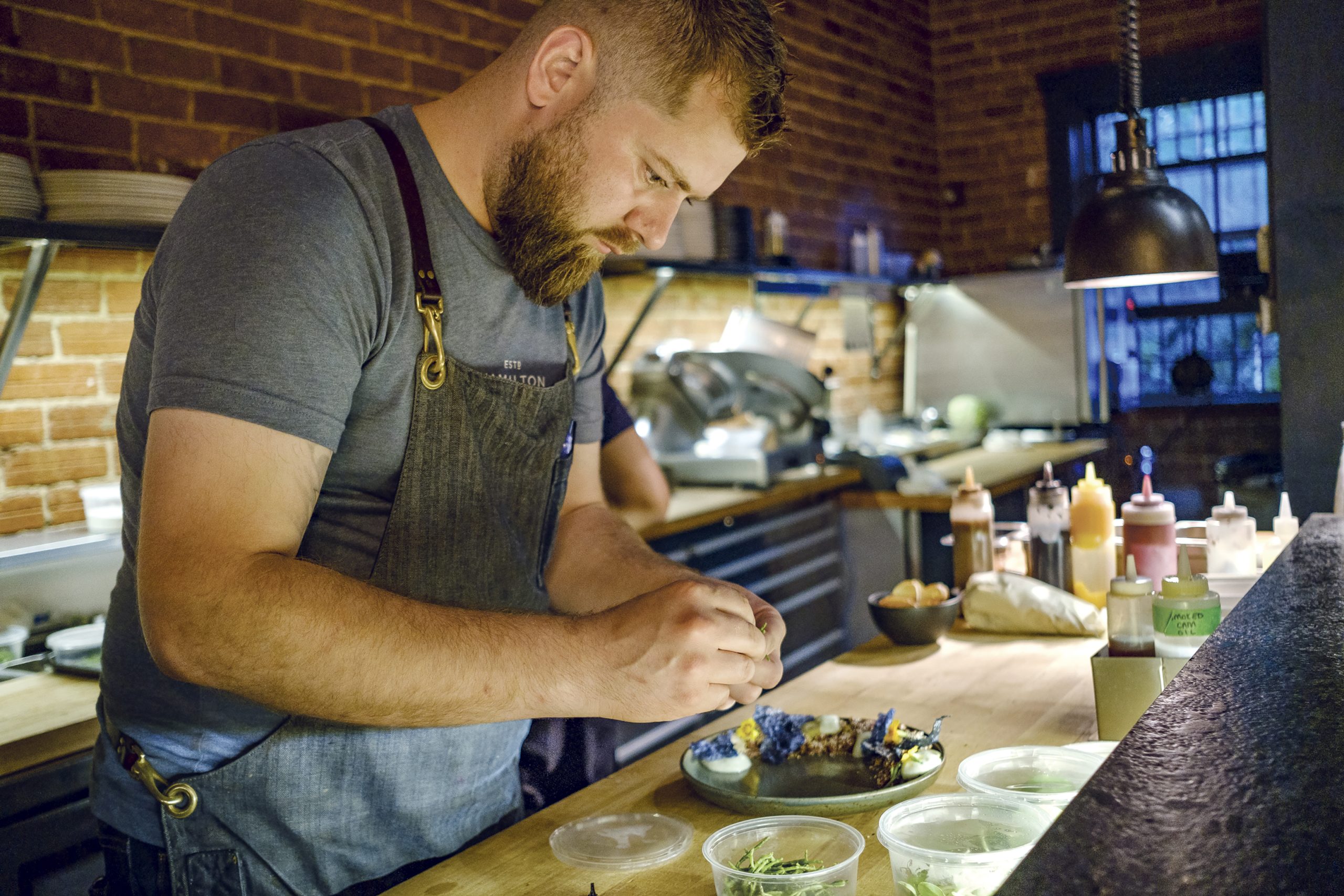 Chec Justin Champagne of Bar Lupulus prepares a dish at his restaurant.