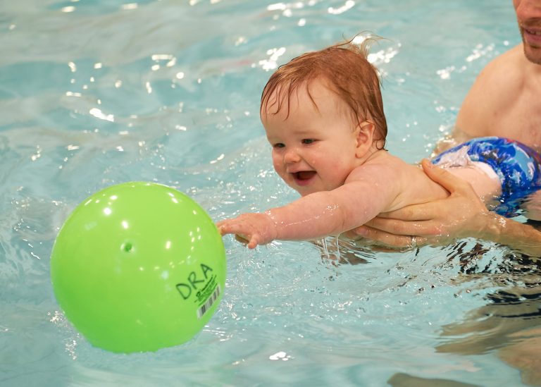 Child reaching for a ball at the Dovercourt Pool.