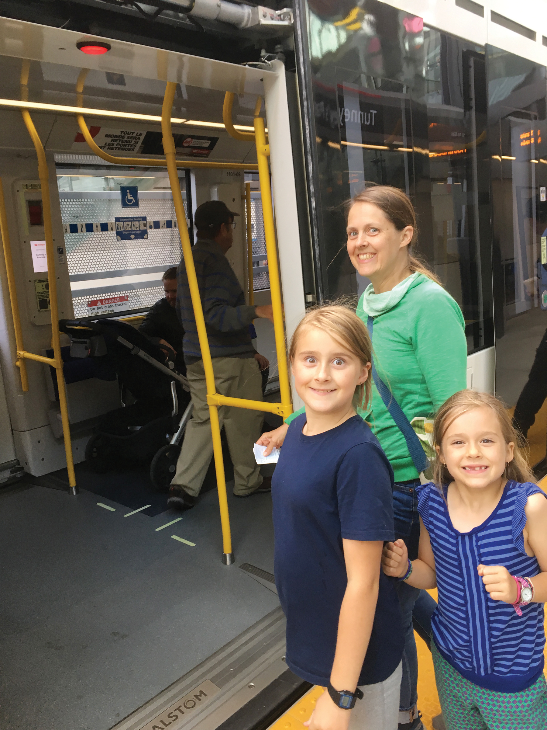 Mom and two kids get ready to board the new Ottawa LRT.