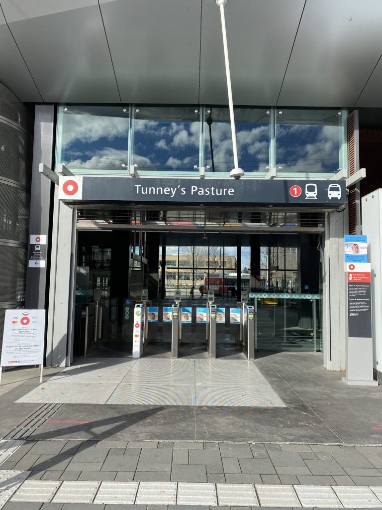 A long shot of the Tunney's Pasture LRT stop entrance on a sunny day.