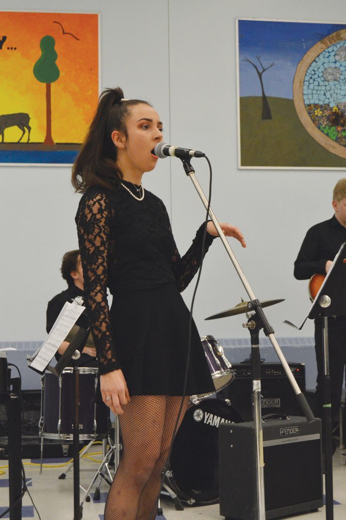 Grade 12 Nepean High School student Meera Thomas singing Feeling Good.|Braeden Moore (center) crouches in despair as Jada Badawy (left)