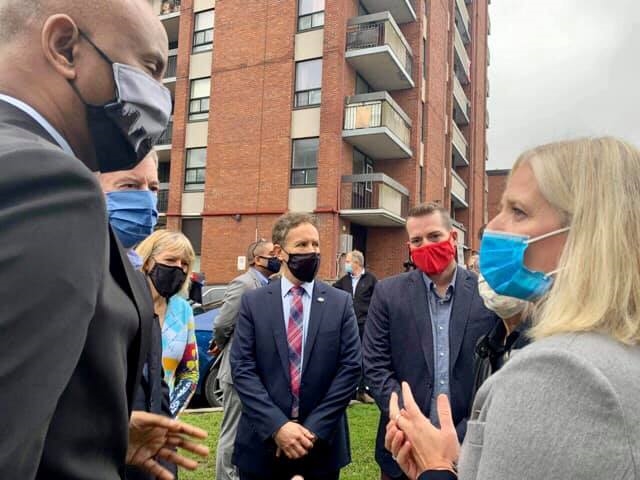 A photo of Minister McKenna, Minister Hussen, Stéphane Giguère outside the new affordable housing construction site in Ottawa.