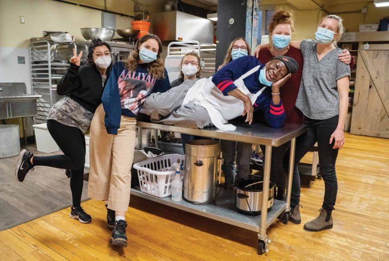 A group of people stand together in the Parkdale Food Centre kitchen.|