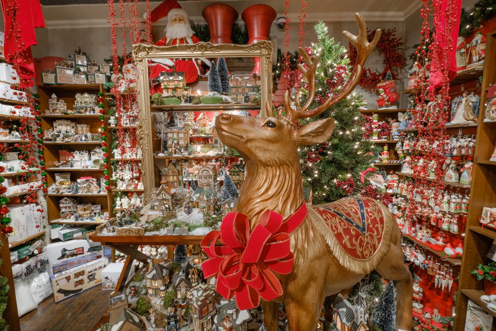 A gold reindeer wearing a red bow stands in Tinseltown in Hintonburg