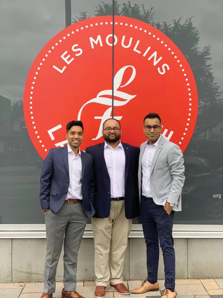 The three co-owners of Les Moulins La Fayette against the company logo in Hintonburg.|Three buns pictured at Les Moulins La Fayette in Hintonburg|The entrance of Les Moulins La Fayette in Hintonburg on a sunny day.