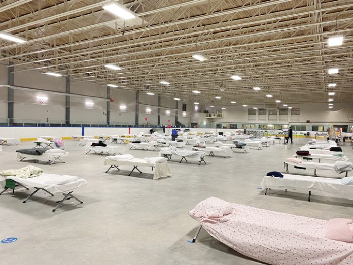 Tom Brown Arena is lit with 70 cots set up on the covered ice surface