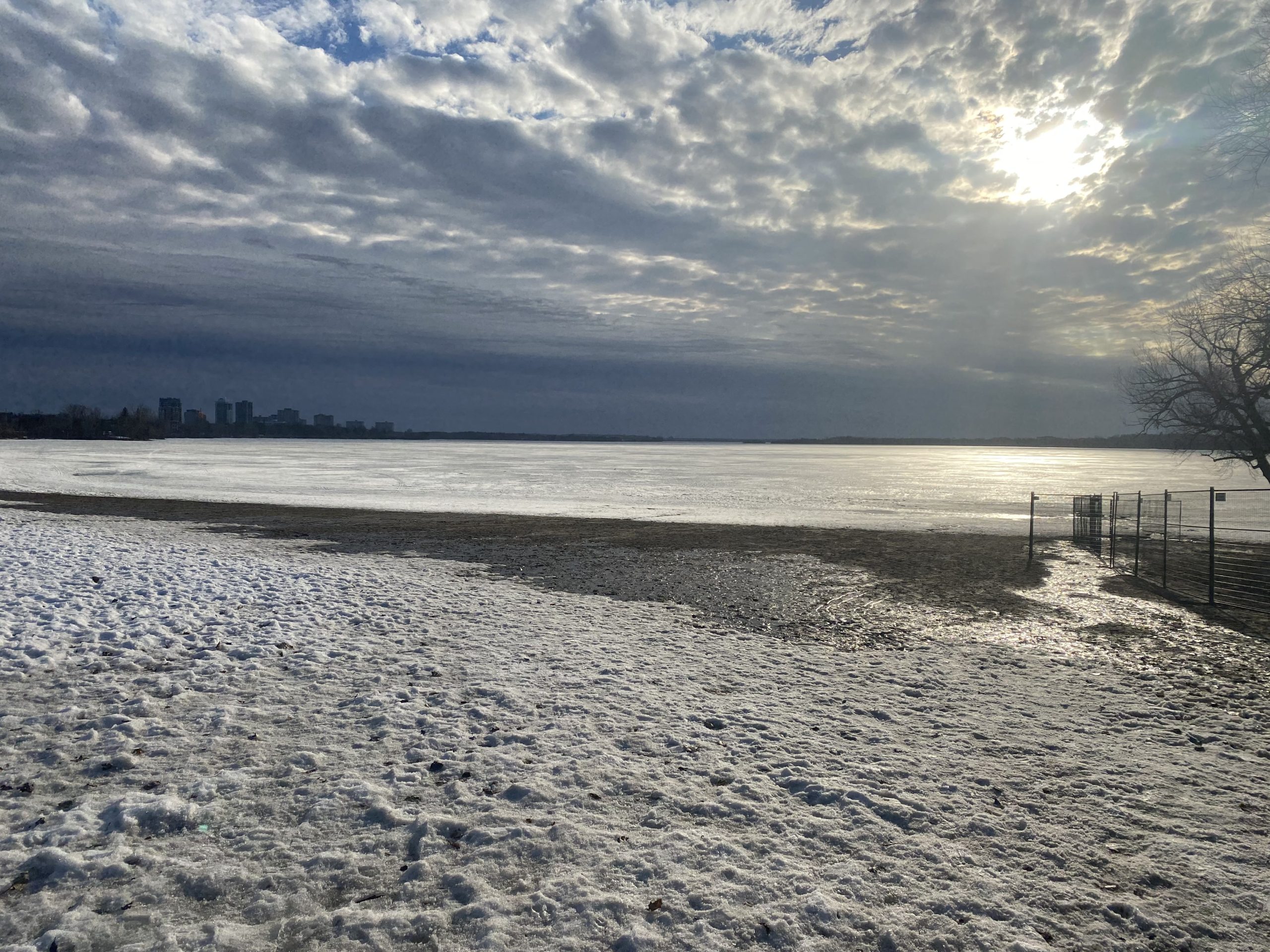 Westboro Beach with a cloudy sunset in the background. The beach is covered with a small layer of snow.