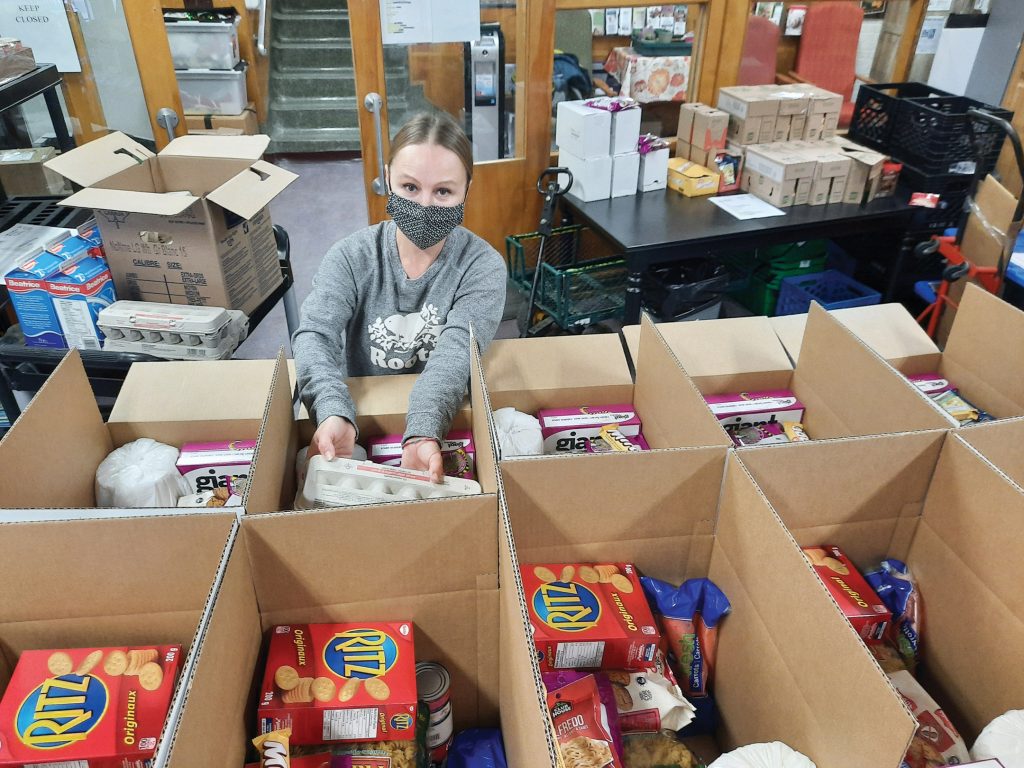 A volunteer fills boxes with food at Ottawa West Community Support's office.