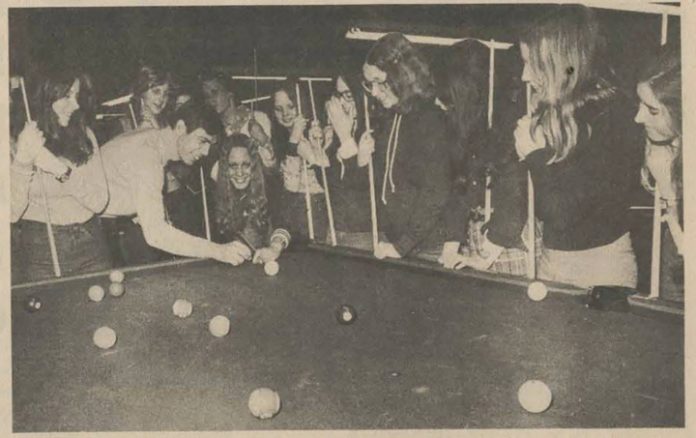 Teenage players gather around a pool table in a black and white photo from 1976||A black and white photo of the Broken Cue building on Richmond Road in the 1970s.|||