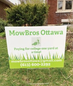 A green and white sign on a lawn that reads "MowBrows Ottawa, paying for college one yard at a time"