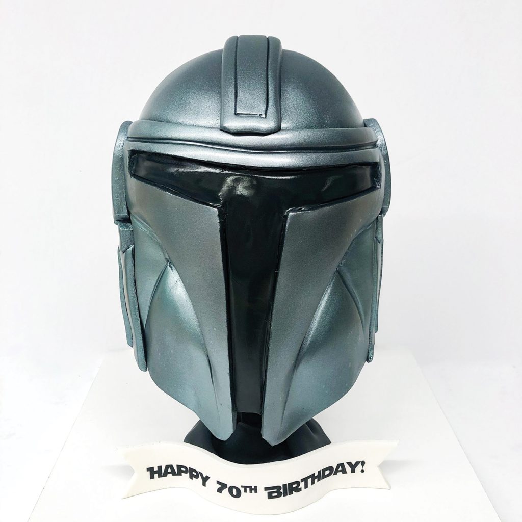 A 3D cake of a silver Star Wars mask.