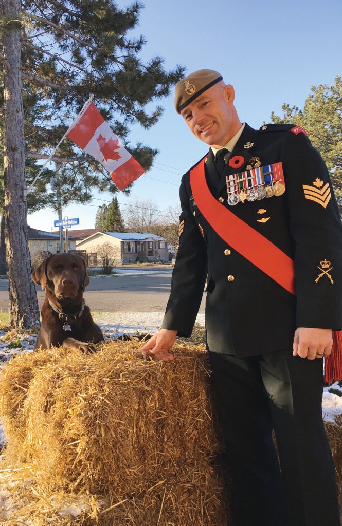 A photo of Randy Turner in uniform outside with his dog.