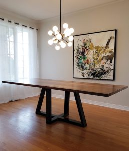 A photo of a walnut table with a geometric base made by Maker House.