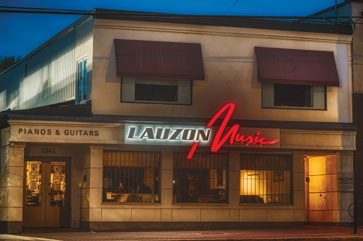 The storefront of Lauzon Music with a red florescent sign|