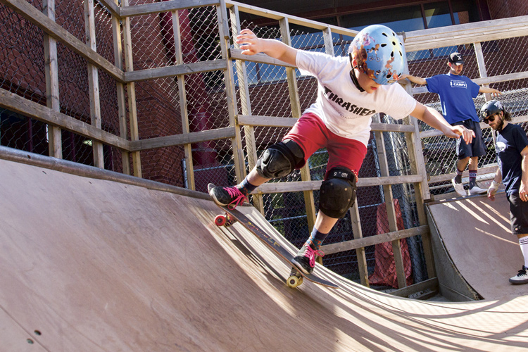 A young boy is seen on a skateboard at a park.