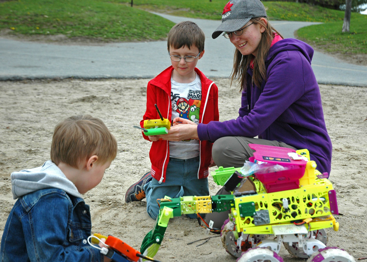 Erin Kennedy shows Miles and Theo Columbus how her beach cleaning bots work.