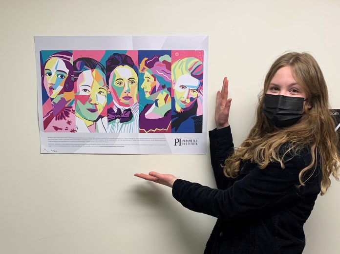 A girl stands next to a multicoloured poster of women in science.