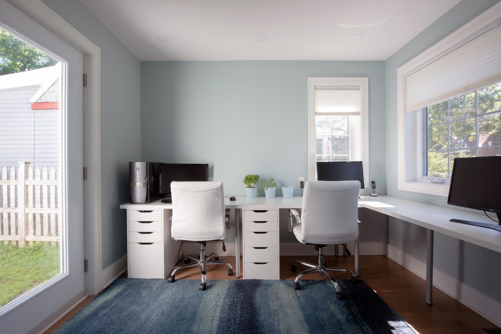 A desk with two stations is seen in a renovated home.