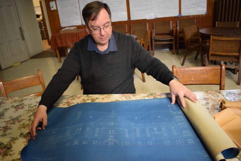 A man looks at drawings for the church. 