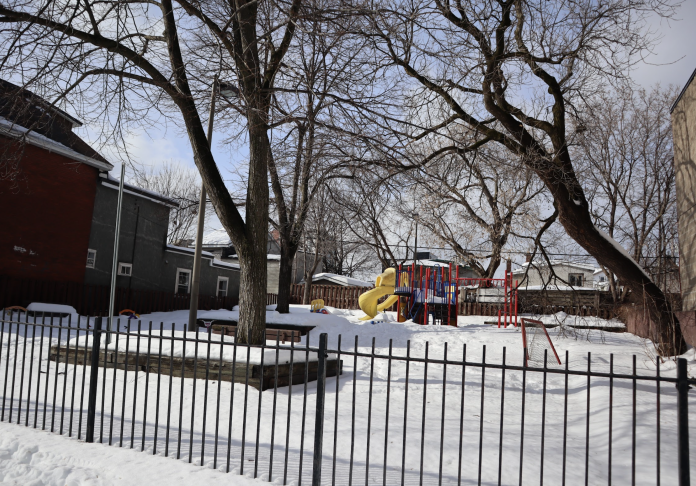 The play structure at Armstrong Park. A black fence is in the front.