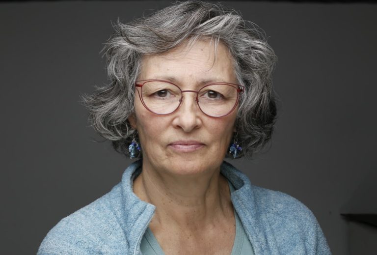 A portrait of Barbara Brown with a grey background.