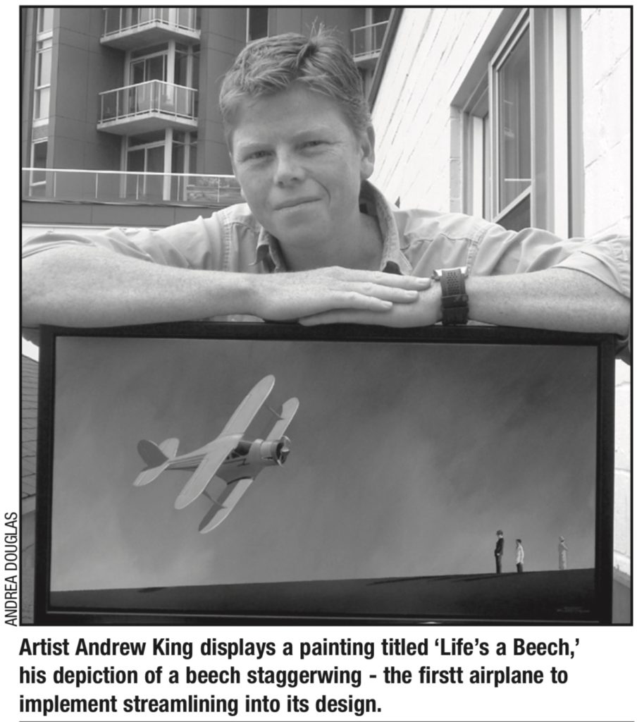 Andrew king poses with one of his paintings. 