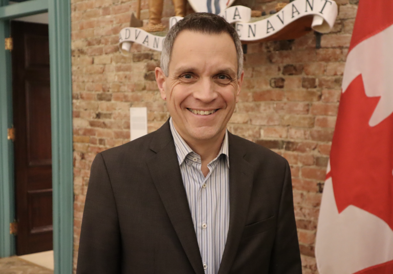 Mark Sutcliffe poses for a photograph in his office