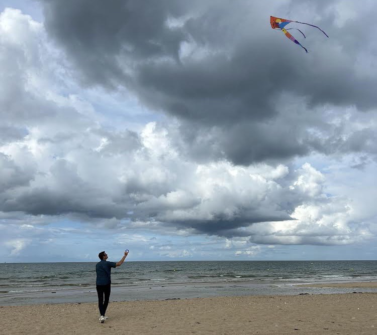 A man flies a kite on a beach. 