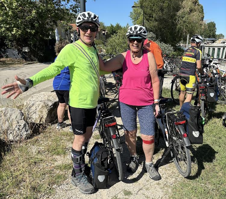 A man and a woman pose for a photo with their bikes. 