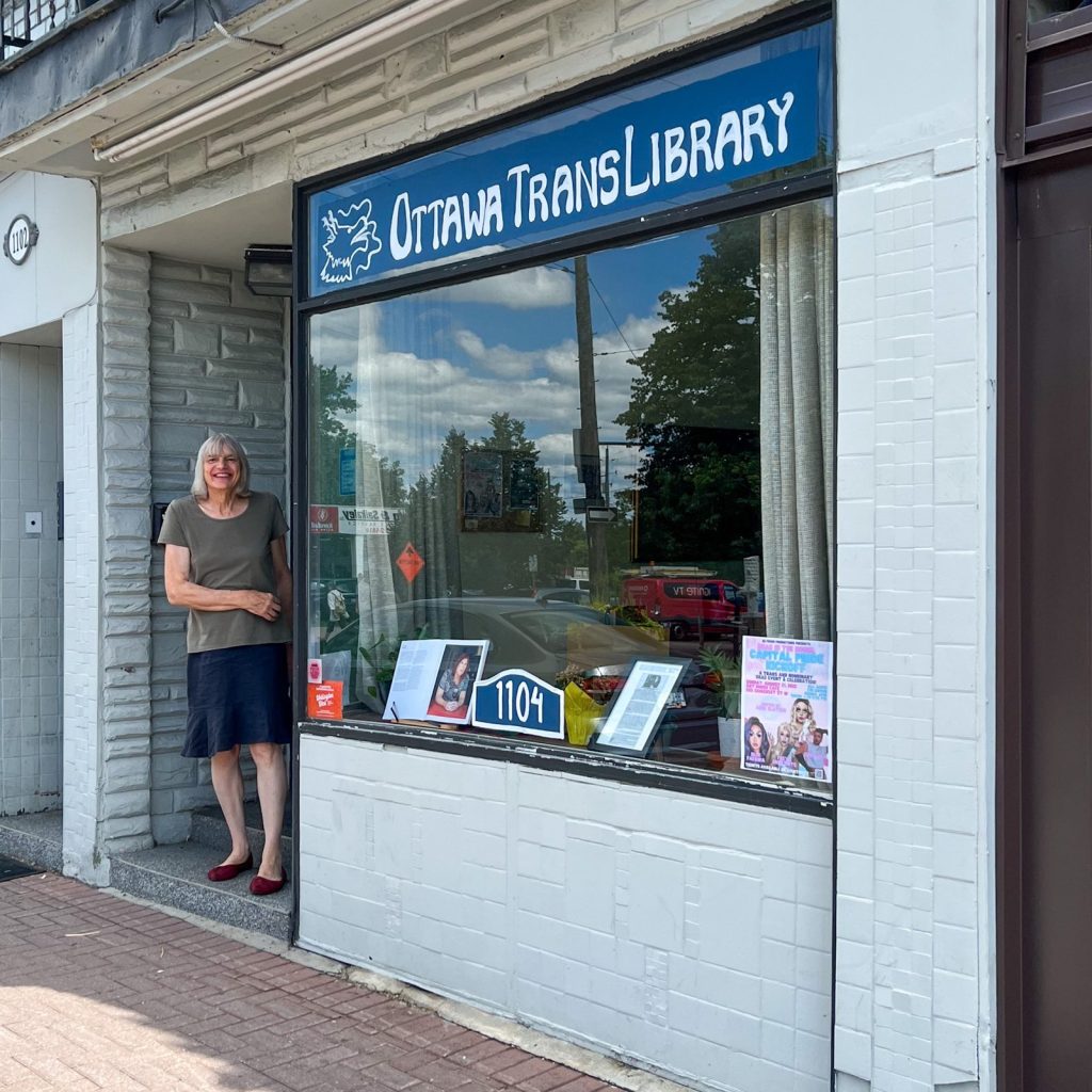 Tara poses for a photograph while standing at the door to the Ottawa Trans Library. 