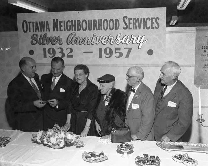 Multiple people are seen celebrating the Ottawa Neighbourhood Services anniversary. It appears to have been taken in 1957.