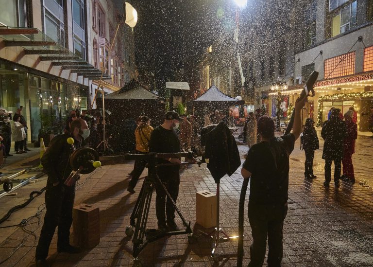 Film crews shoot a movie on Sparks Street. Fake snow is being blown in the air