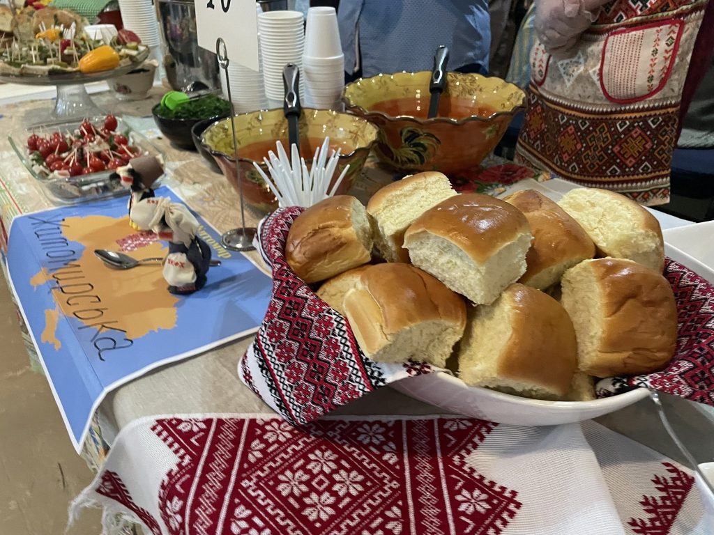 Buns and some other desserts are displayed on a table. 