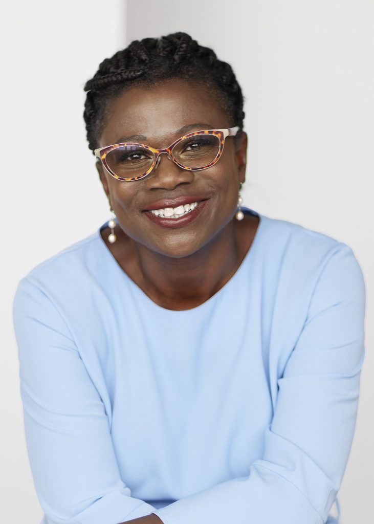 A photo of Renée wearing a white blue long sleeved shirt with a white background. 