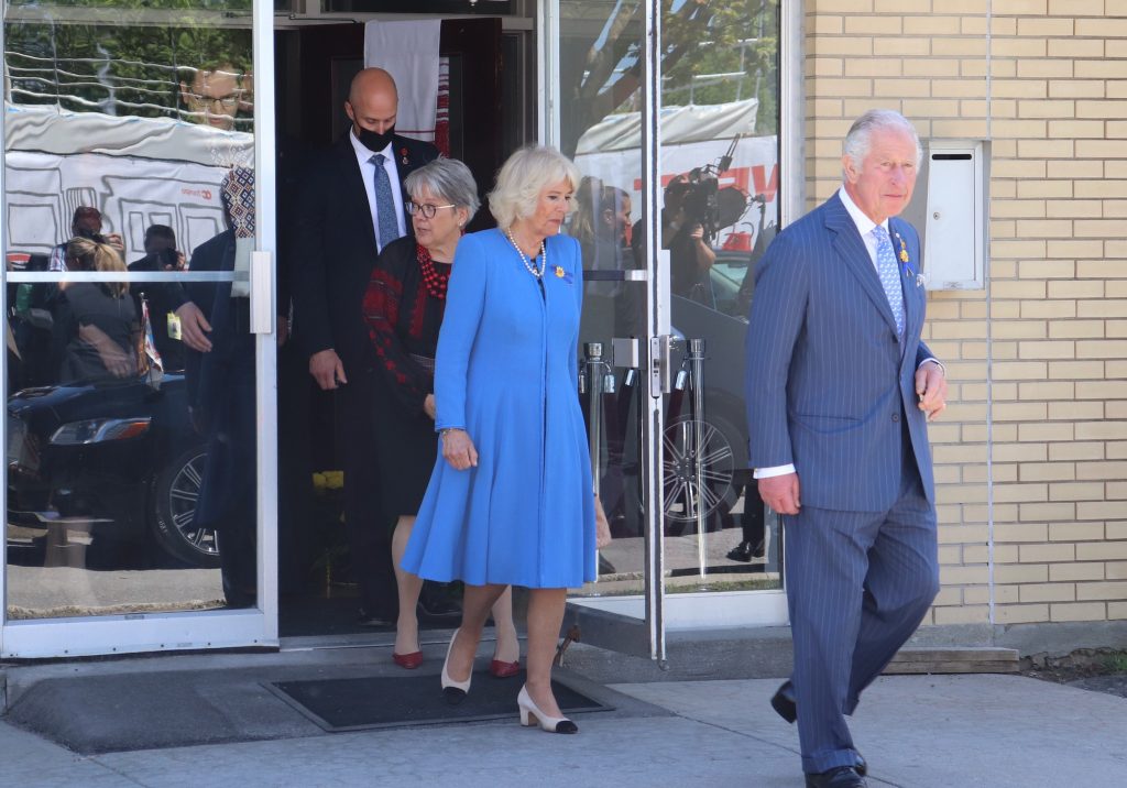 Queen Camilla and King Charles walk out of the Ukrainian church’s front entrance.