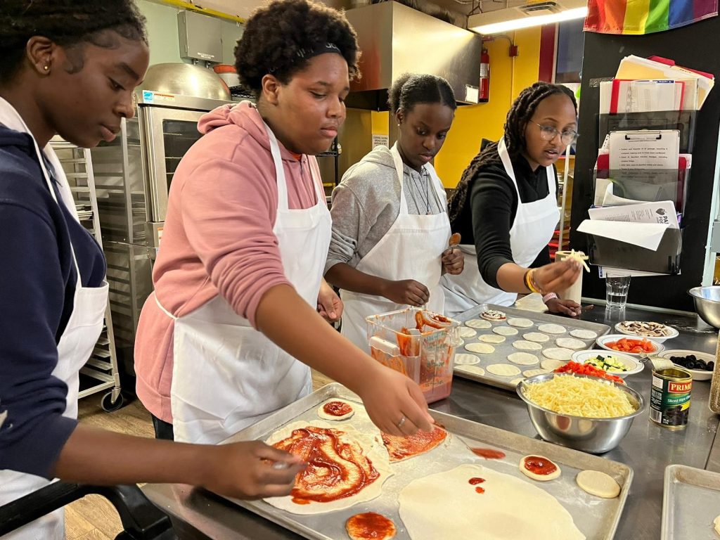 Four ladies make a meal in the Parkdale Food Centre kitchen. 