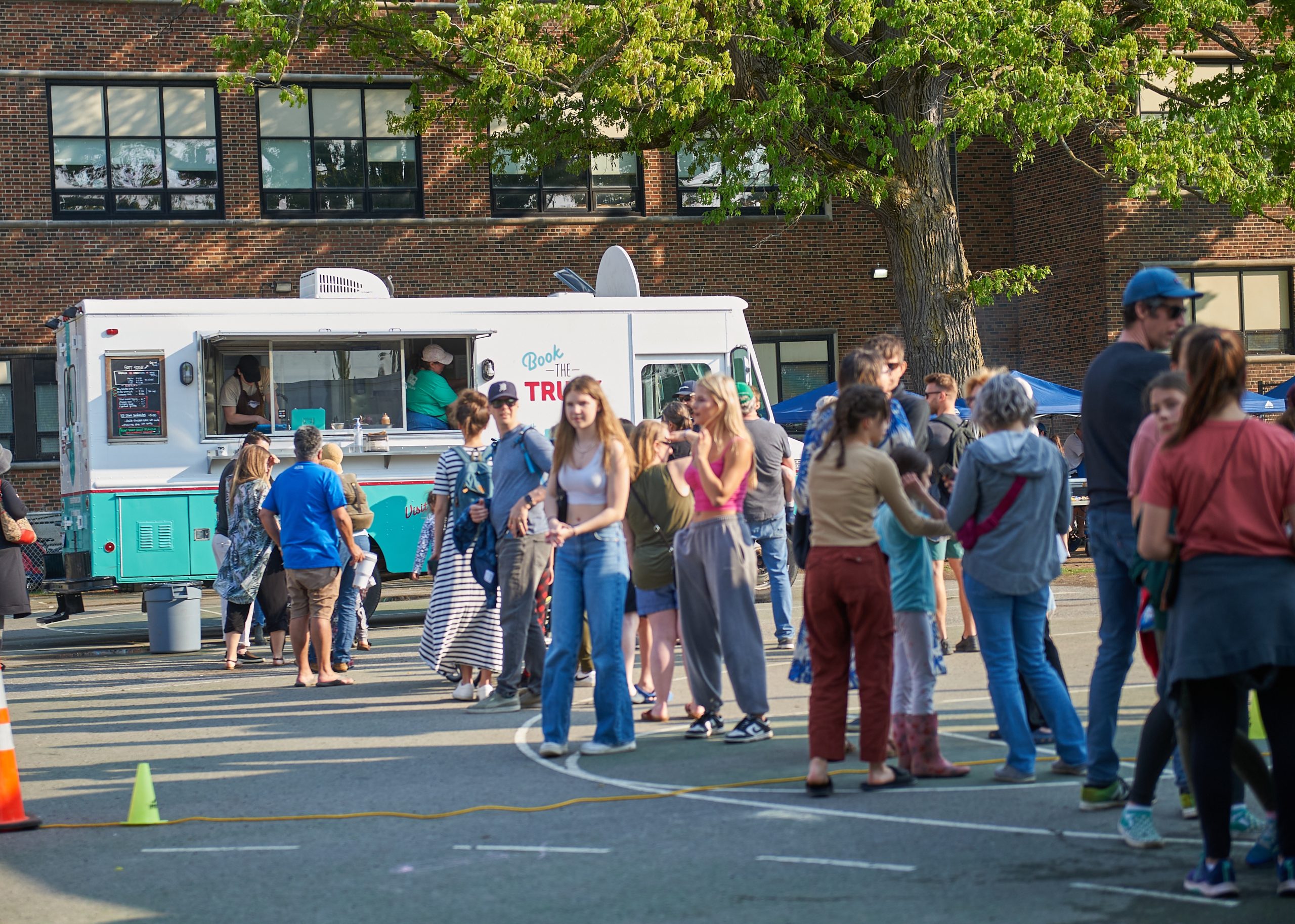 People stand in line to get ice cream from the Merry Dairy ice cream truck.