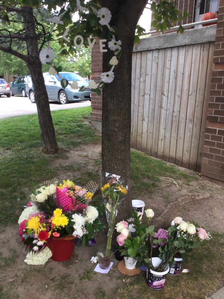 Flowers sit under a tree near the Hilda Street apartment.  