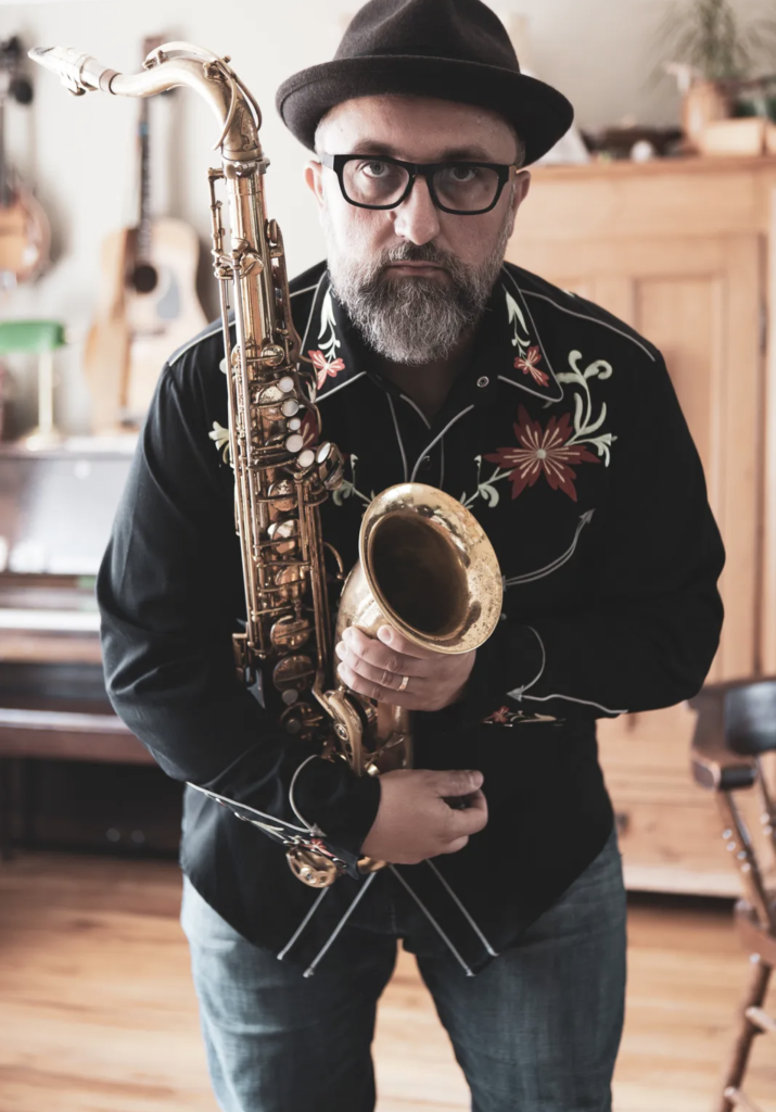 Petr poses for a photograph while holding an instrument.