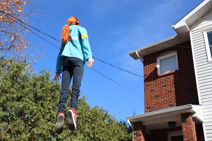 A near life size version of Stranger things character Max z mayfield floats above the front yard of a home