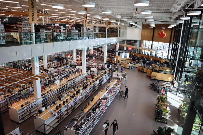 A photo taken from the second flood of Canadian Tire. It looks down to shelves stocked with Kitchen equipment. Cashes with customers are also seen in the distance.